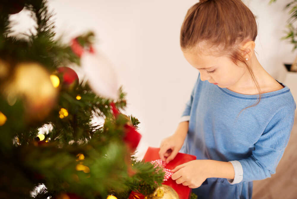 dziewczynka przygotowuje prezenty świąteczne